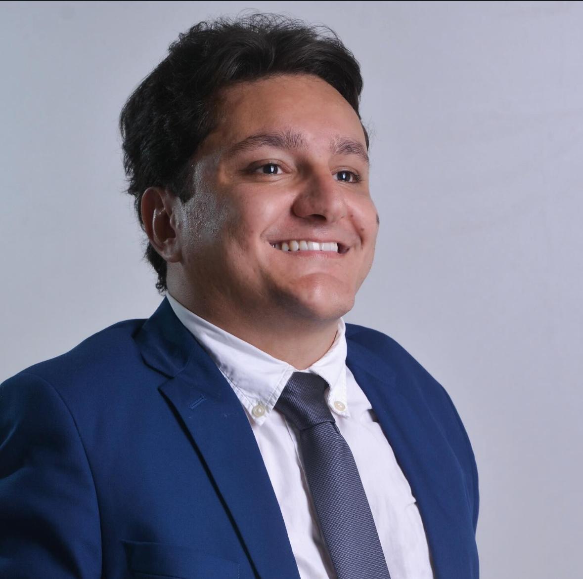 Retrato do advogado Matheus Divino Fernandes, de terno azul e gravata